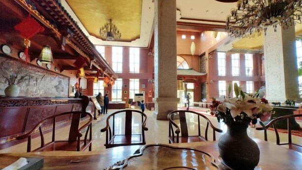 A spacious lobby with high ceilings, large windows, and traditional decor. - Yijia Hotel (Wuding)