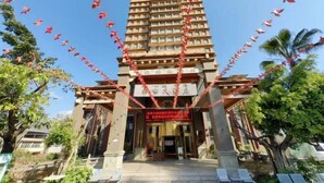 A hotel entrance with a traditional architectural style, featuring a central entrance flanked by two columns and a red banner above. - Yijia Hotel (Wuding)