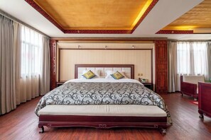 Ein Hotelzimmer mit einem großen Bett, Holzboden und einer dekorativen Decke.