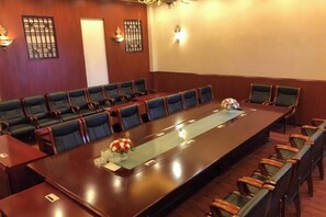 Une salle de conférence avec une longue table, de nombreuses chaises et un élément décoratif au centre.