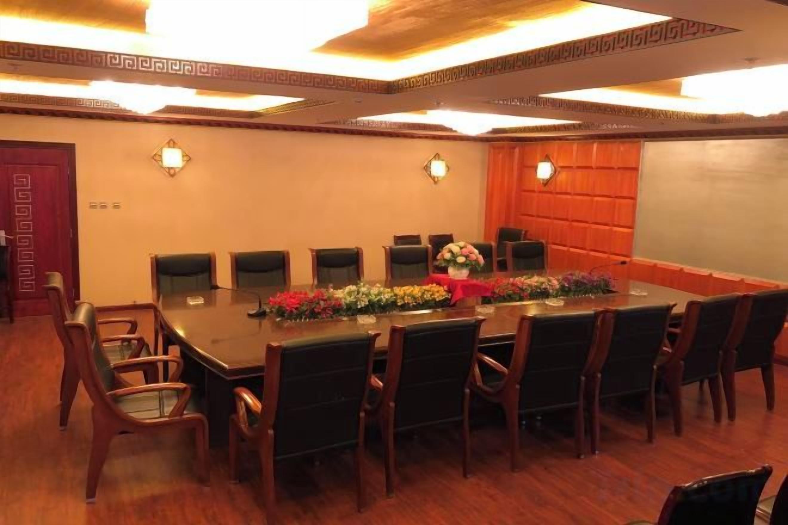 A conference room with a long table, chairs, and a whiteboard.