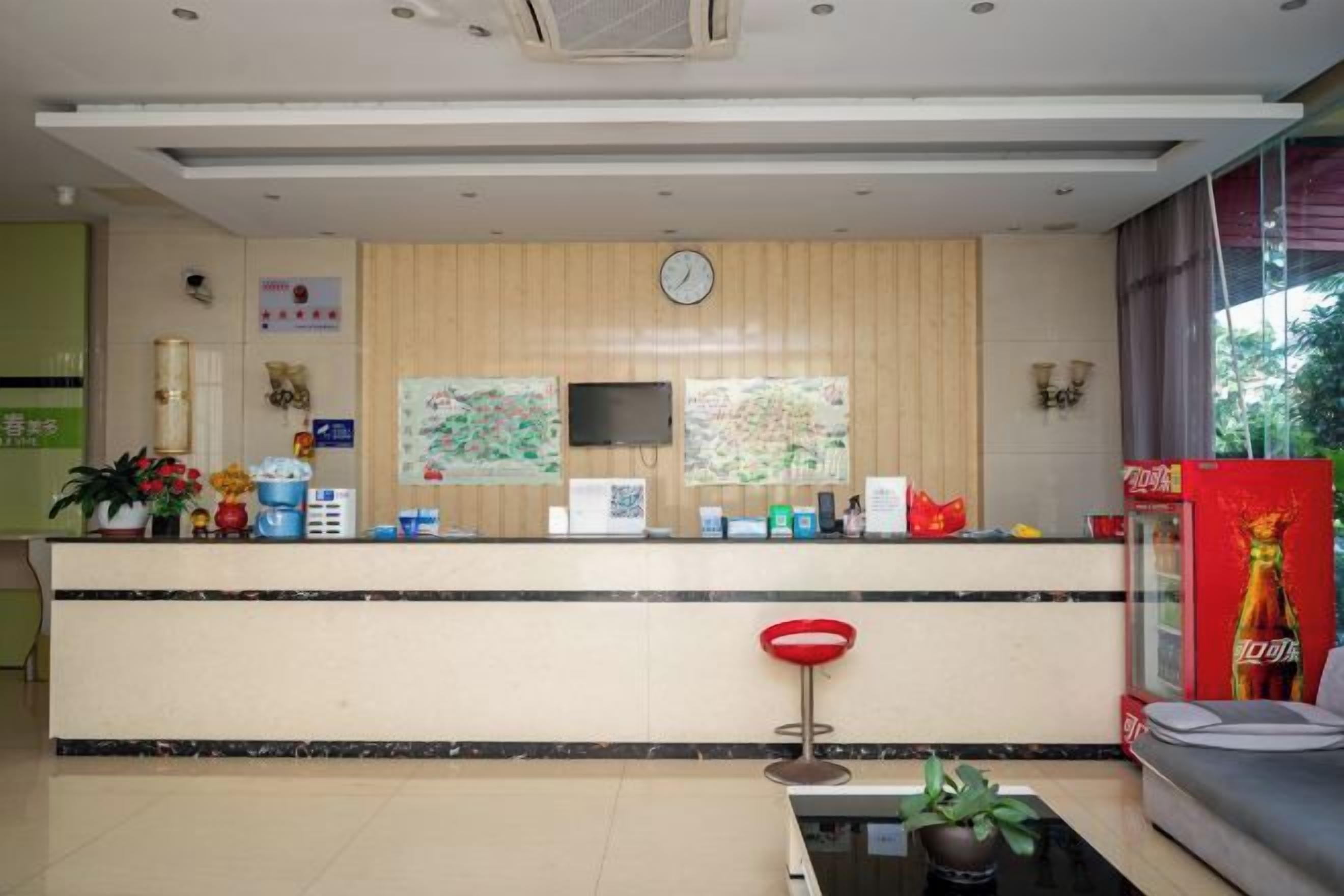A reception area with a counter, a clock, and a television.
