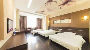 A hotel room with two beds, a desk, a chair, and a TV.