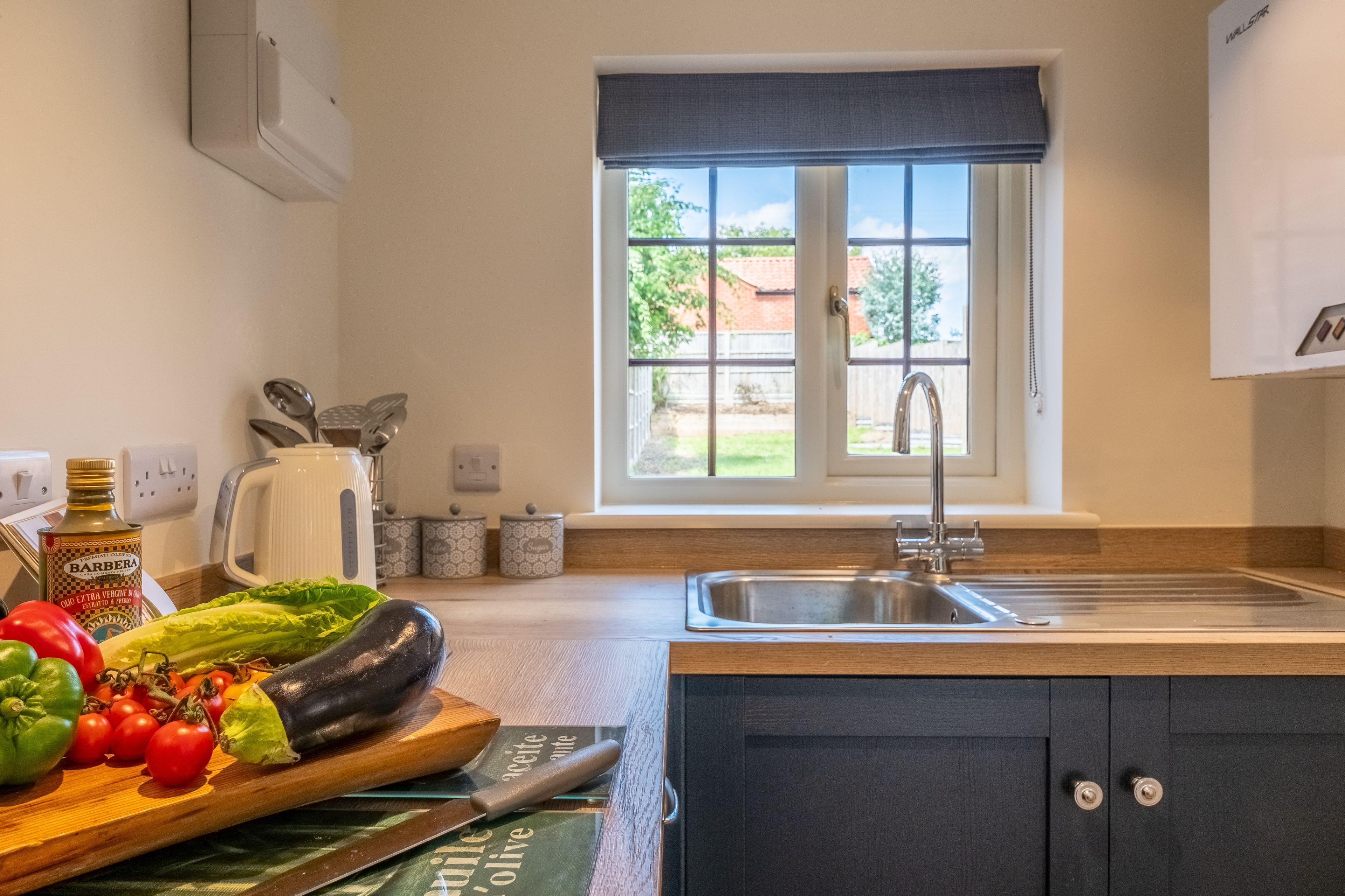 Een keuken met een houten aanrecht, een gootsteen en een raam met uitzicht op buiten.