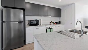 A modern kitchen with a stainless steel refrigerator, a microwave, a toaster, and a sink. - 4-13 Central Dr Victor Harbor - Wi-Fi and Linen (Victor Harbor)