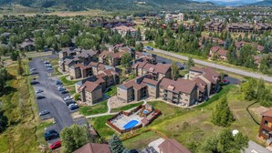 Un quartier résidentiel comprenant plusieurs immeubles d’appartements, un parking et une piscine.