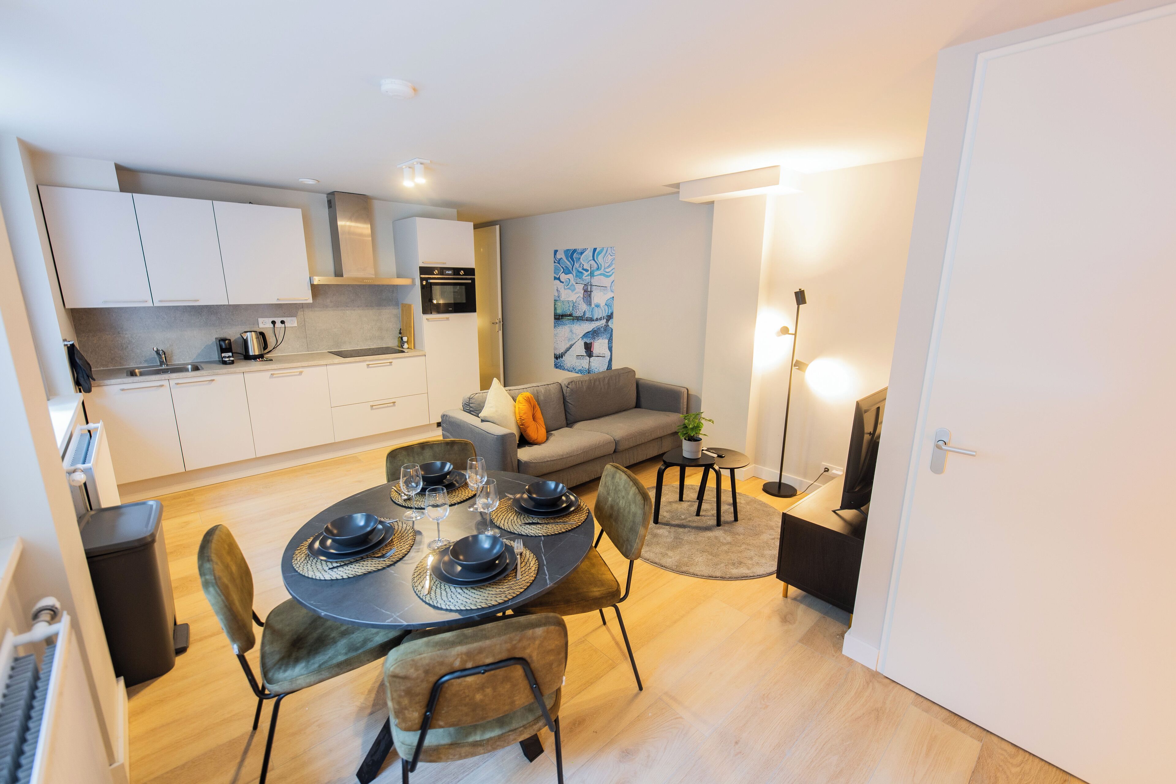 A modern apartment with a dining area, kitchen, and living space.