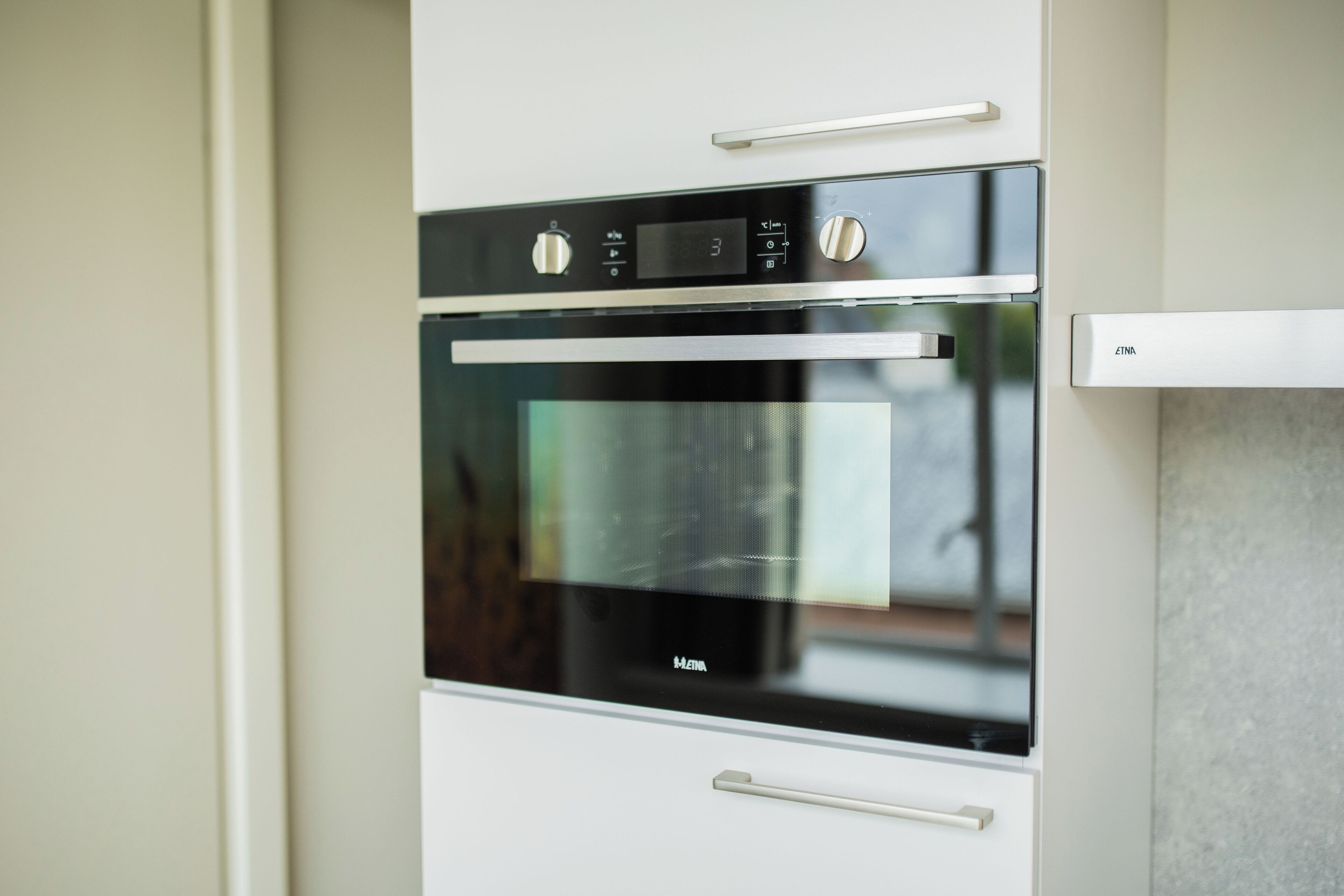 Una cocina moderna con horno empotrado y microondas.
