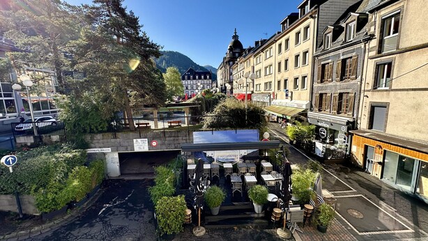 Straßenansicht mit Café-Terrasse, einem Schild für 'Pantheon' und einem Parkschild.