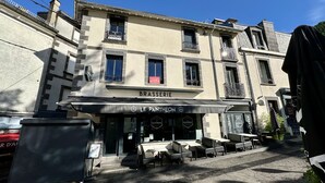 Ein Gebäude mit einer Schaufensterschild, auf dem "BRASSERIE" und "LE PANTHEON" steht.