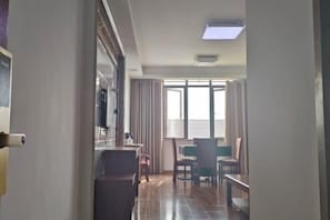 A hotel room with a dining area, a large window with curtains, and a ceiling light. - Hai'an Tangrenxuan Business Hotel (Hai'an)
