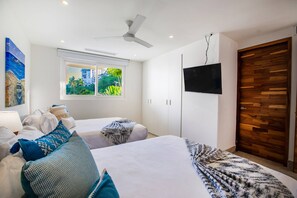 Ein modernes Schlafzimmer mit einem Bett, einem Fernseher, einem Fenster mit Blick und einem Deckenventilator.