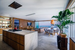 Une cuisine moderne dotée d’un grand îlot central, de meubles en bois et d’un téléviseur à écran plat.