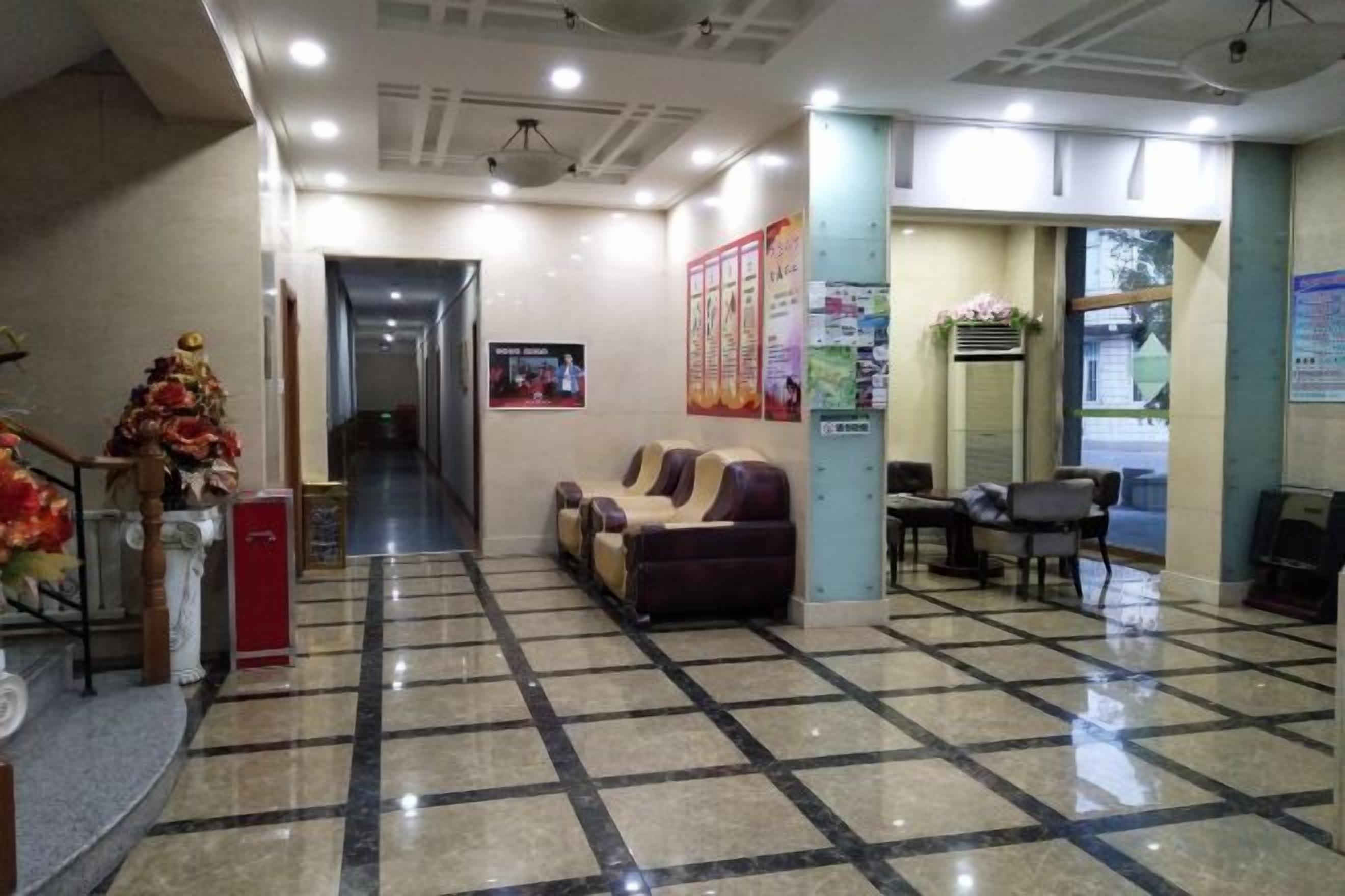 A reception area with a checkered floor, a reception desk, a waiting area with a sofa, and a poster on the wall.