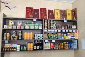 A shelf stocked with various packaged goods, including snacks, beverages, and personal care items.