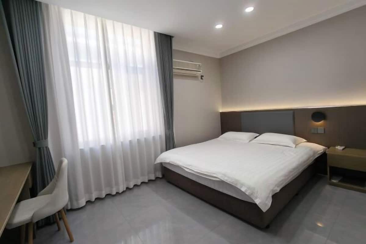 Una habitación de hotel moderna con cama, escritorio y silla.