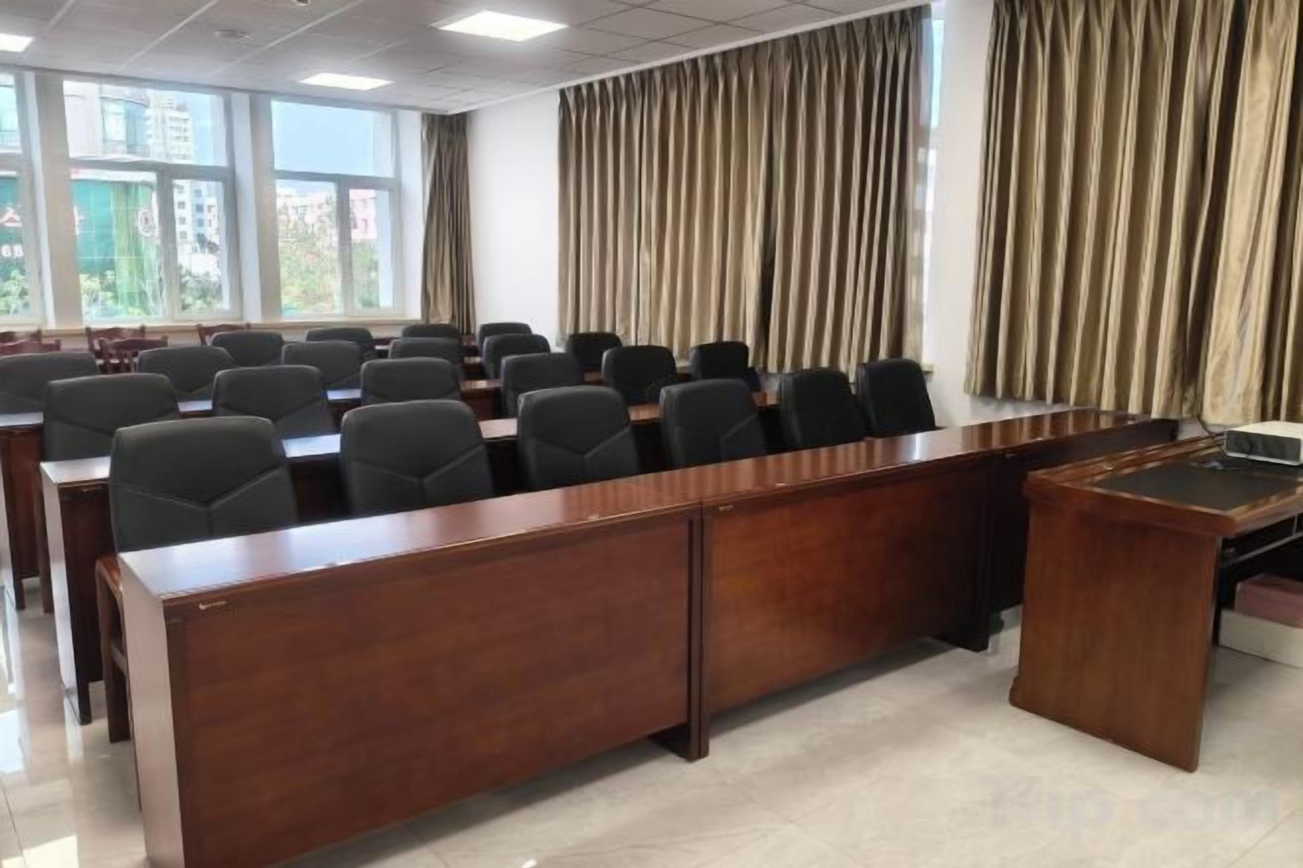 A conference room with a long table, chairs, and a podium.