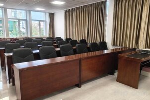 A conference room with a long table, chairs, and a podium.