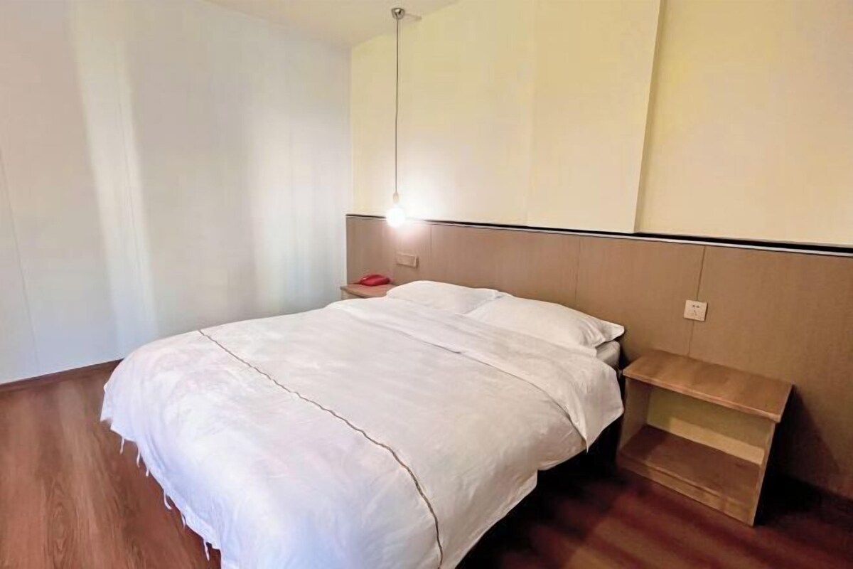 Une chambre à coucher avec un lit, une table de chevet et une commode.