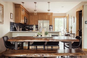 Una cocina moderna con armarios de madera, una isla grande e iluminación colgante.