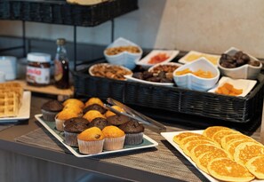 A buffet with various baked goods including muffins, waffles, and pastries. - Manalodj (Saint-Raphael)