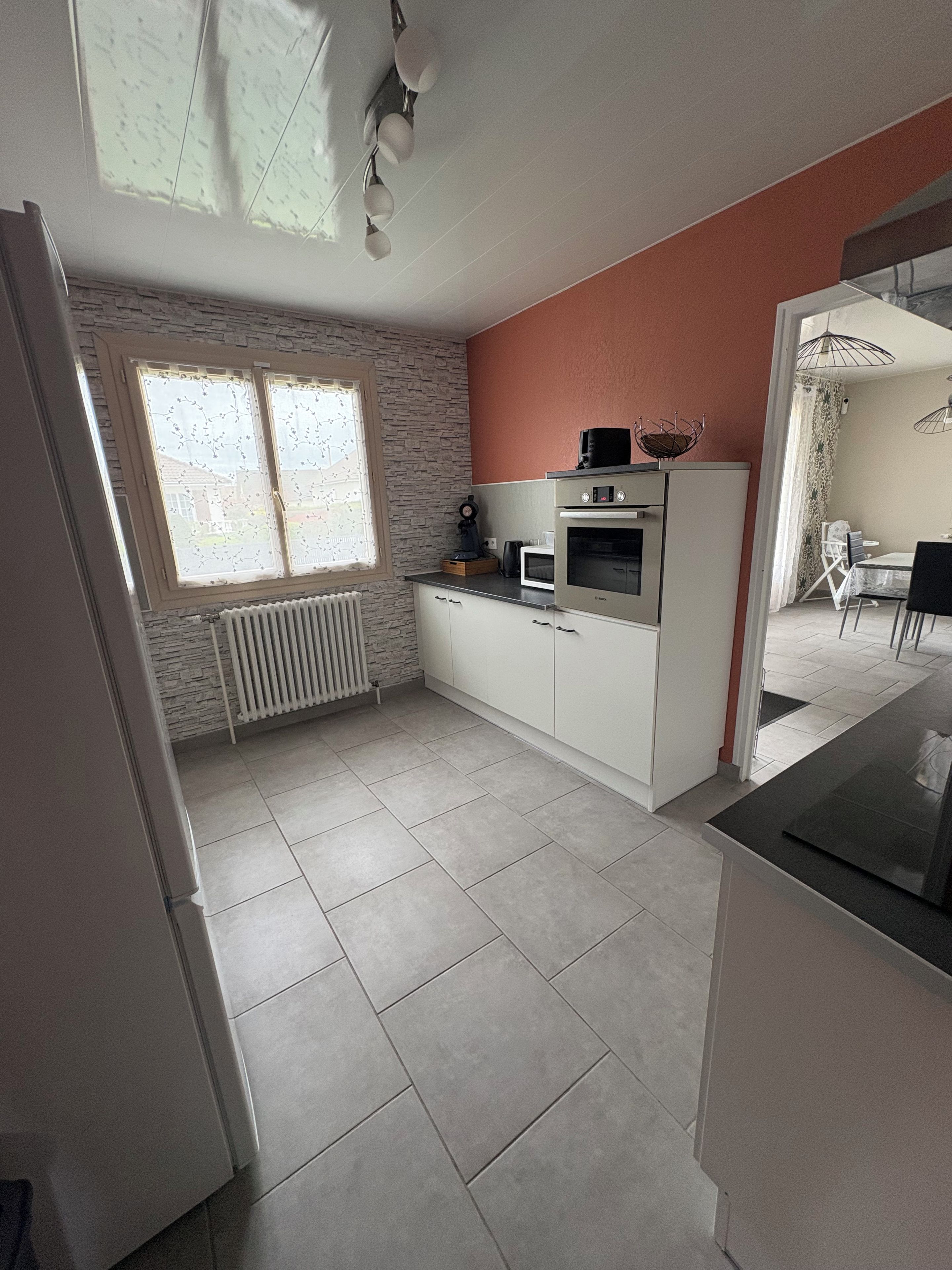 A compact kitchen with a built-in oven, microwave, and a coffee maker on the countertop.