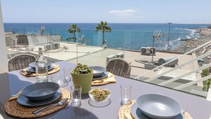 A table set for two with a view of the sea and beach.