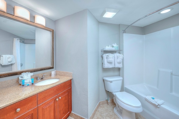 Un bagno con lavandino, specchio, water e vasca da bagno.