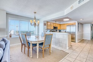 Une cuisine spacieuse avec un coin repas, un lustre et une vue sur un chantier de construction.