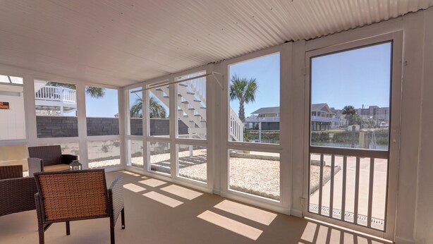A spacious balcony with a view of a residential area and a staircase.