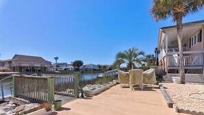 A waterfront property with a dock, outdoor seating, and a view of the water.