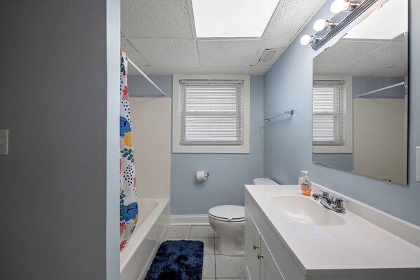Une salle de bain équipée d’une baignoire, de toilettes, d’un lavabo et d’un miroir.
