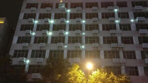 A building with multiple air conditioning units and a sign with illuminated text. - Huadu Business Hotel Chenzhou (Chenzhou)