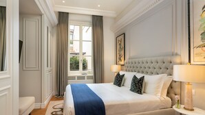 A hotel room with a large bed, a sitting area, and a window with curtains. - Pazzi Penthouse By Geco Vacation Rentals (Florence)