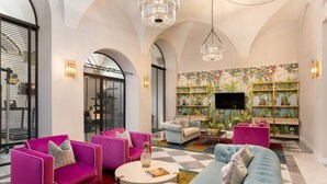 A spacious living room with a checkered floor, a large sofa, and vibrant armchairs. - Pazzi Penthouse By Geco Vacation Rentals (Florence)