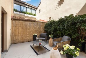 A patio with a table, two chairs, and a wicker sofa. - Pazzi Penthouse Luxury Apartment In Florence By Palace Pazzi Vitali (Florence)