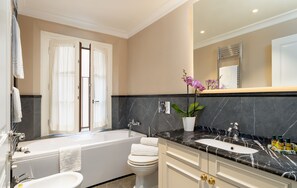 A modern bathroom with a bathtub, toilet, sink, and a large mirror. - Pazzi Penthouse Luxury Apartment In Florence By Palace Pazzi Vitali (Florence)
