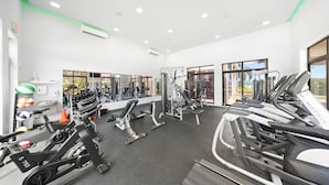 Ein Fitnessstudio mit Laufbändern, Crosstrainern und Kraftgeräten.