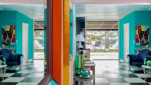 Une pièce aux murs de couleur turquoise, avec un sol à carreaux et deux fauteuils bleus.