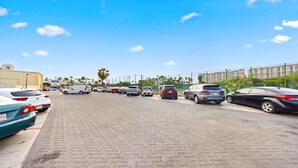 A parking lot with multiple cars and a building in the background.
