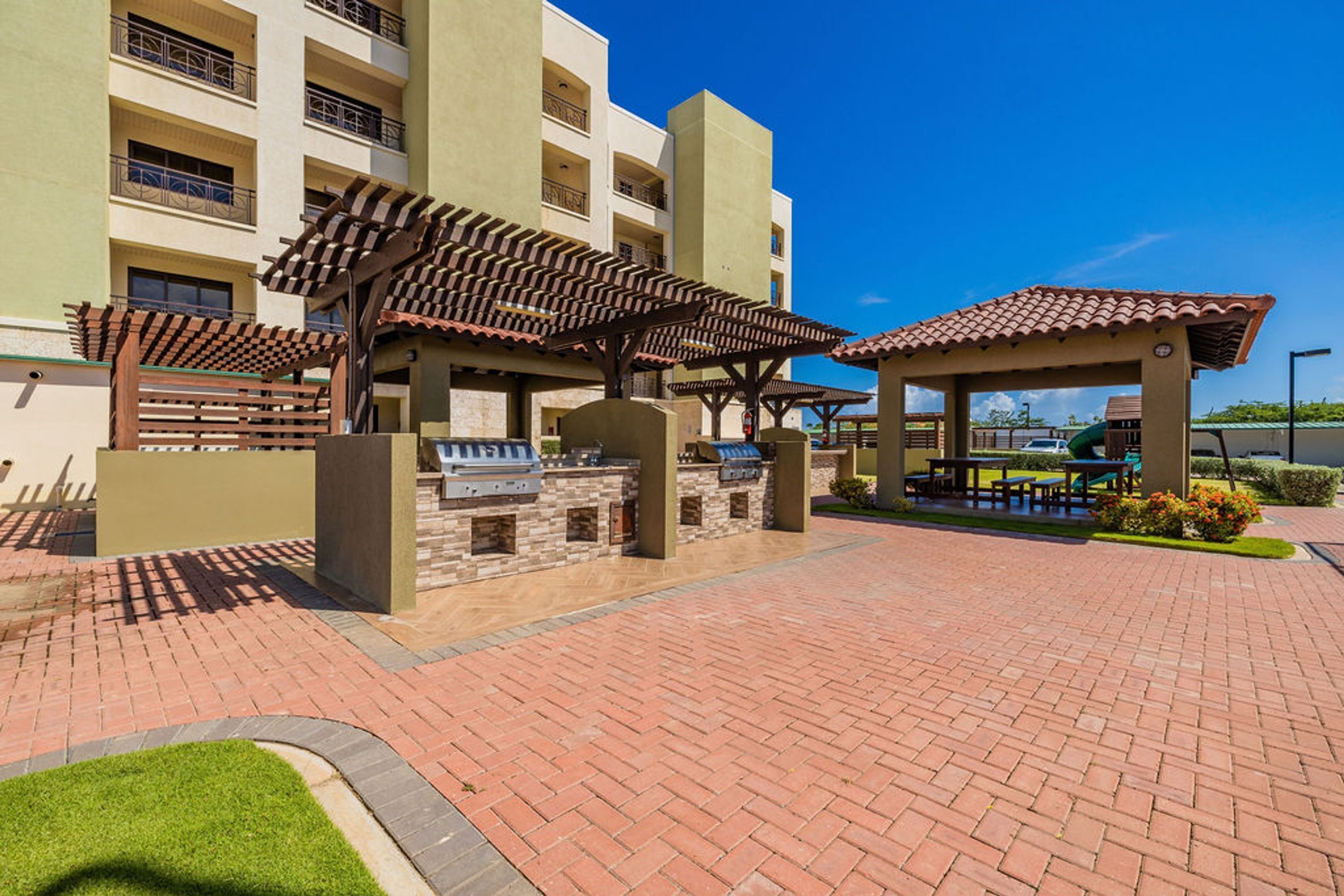 A courtyard with outdoor seating, a barbecue area, and a covered pavilion.