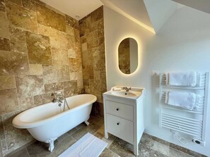 A bathroom with a freestanding bathtub, a vanity with a mirror, and a towel rack. - Résidence CH-MAISONS (Cricqueboeuf)