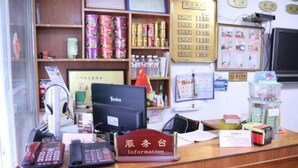 A reception desk with a computer, phones, and various informational materials.
