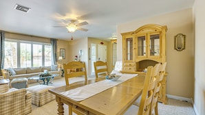 A dining area with a wooden table, chairs, and a cabinet. - Near Surprise Stadium! Home w/ Pet-Friendly Yard (Sun City West)