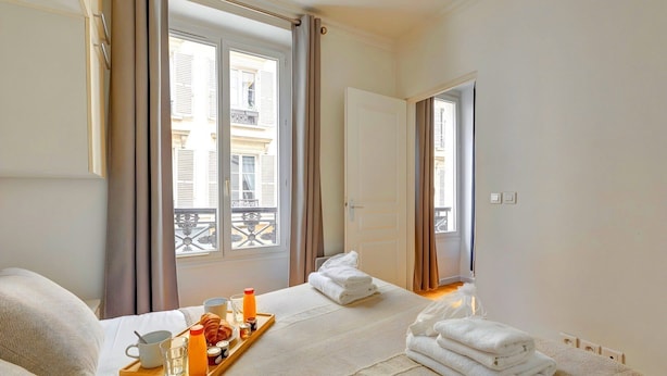 Ein Hotelzimmer mit Bett, Frühstückswagen und Blick auf den Balkon.