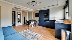 A modern apartment with a dining area, kitchen, and living room.