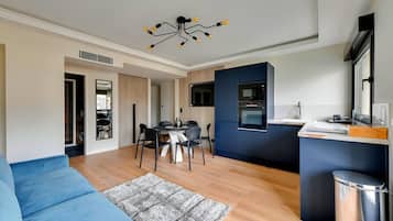 A modern apartment with a dining area, kitchen, and living room.