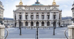 Stunning facade of the Conservatoire National Supérieur de Musique, featuring a grand entrance with intricate carvings and a distinctive green dome.
