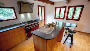 Una cucina con isola centrale, mobili in legno, un piano cottura e un lavello.