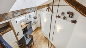 Una cocina moderna con tragaluz, vigas de madera y pequeñas figuras de animales decorativas en la pared.